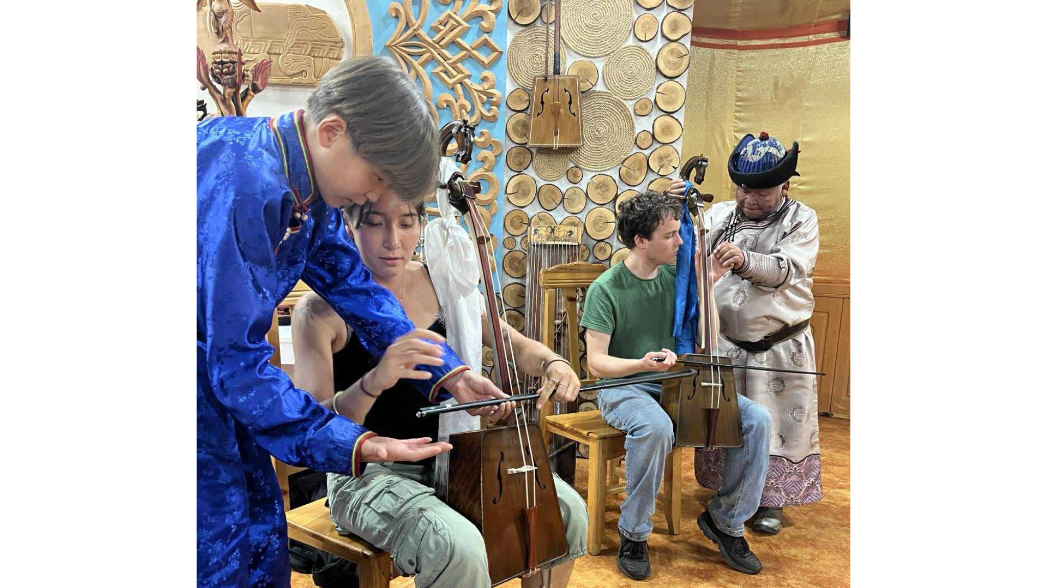 ANU students learning the horse-head fiddle (morin khuur) in the ancient capital of Kharkhorin. Modern Mongolia field course, July 2025. Photo: Batjav Bayartuul.
